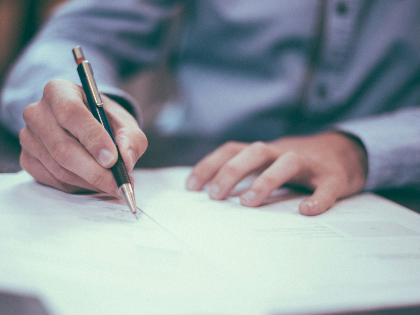 man writing on paper